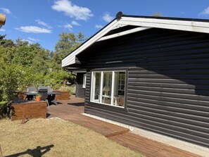 A single-story cabin with a deck, a barbecue grill, and a patio table. - "Andrina" - 490m from the sea by Interhome (Sæby)