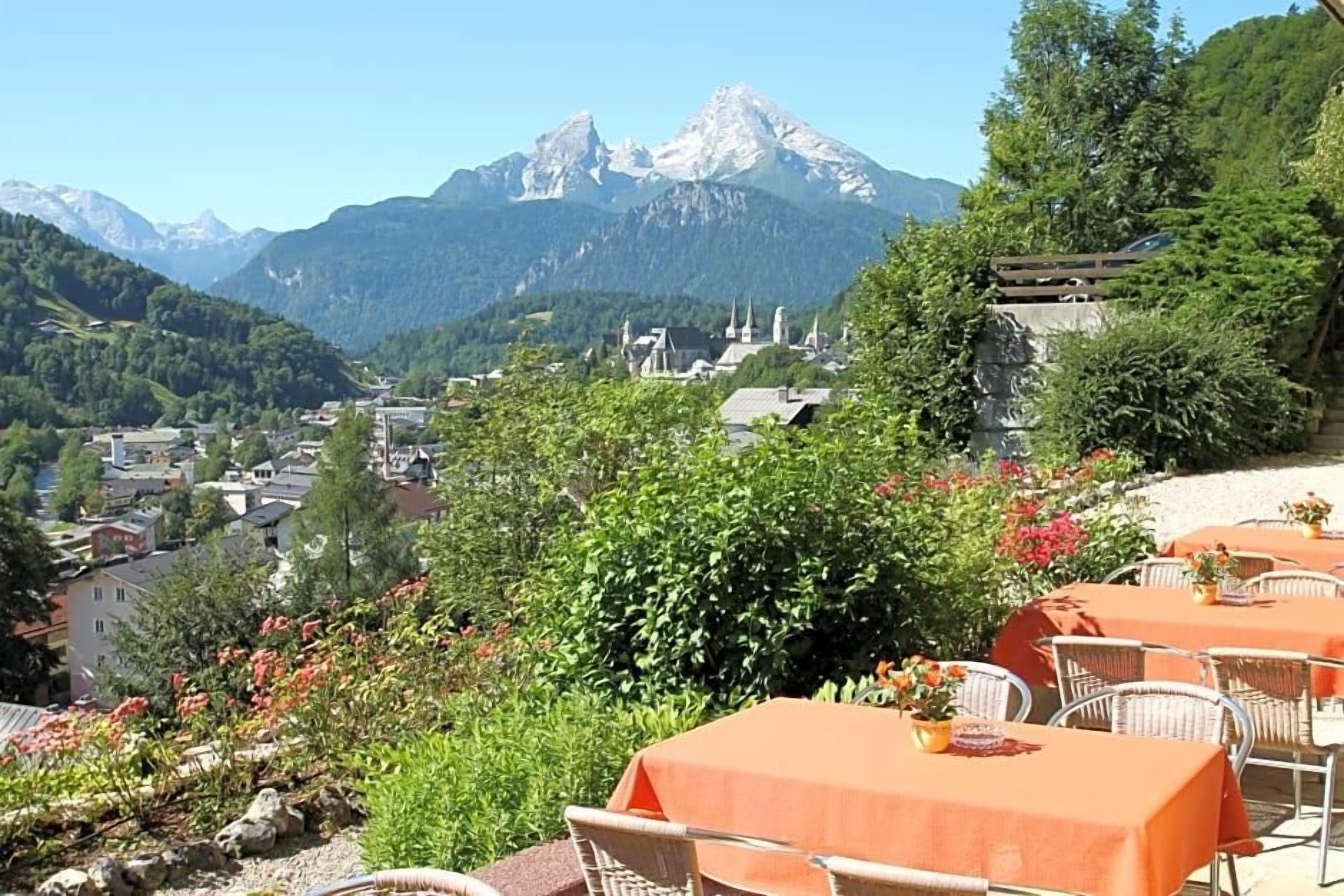 Een restaurant met terras, met uitzicht op een bergachtig landschap.