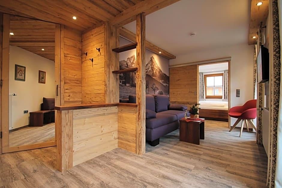 Un interior de madera con un sofá, una silla roja y una ventana.