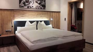 Ein Schlafzimmer mit einem großen Bett, einem hölzernen Kopfteil und einem Gemälde darüber.