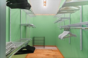 Ein Zimmer mit grünen Wänden, Holzboden und Regalen aus Metall für Handtücher.