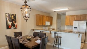 A kitchen with wooden cabinets, a microwave, and a refrigerator. - Waterfront Condo w/ Boat Docking & Fishing (Foley)