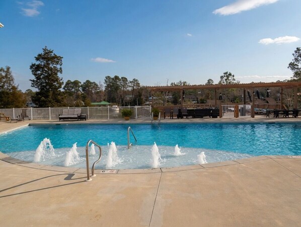 A swimming pool with water jets, a covered seating area, and a fenced deck. - Waterfront Condo w/ Boat Docking & Fishing (Foley)