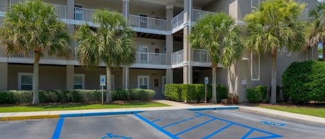 A multi-story hotel with a parking lot marked for disabled access.