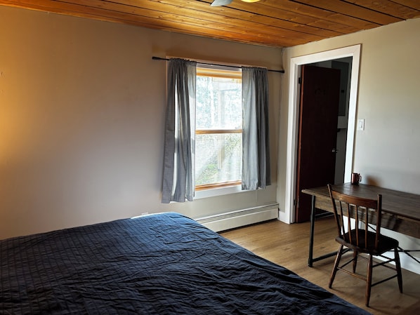 Una habitación con cama, escritorio y silla.