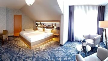 Ein Hotelzimmer mit Bett, Schreibtisch, Stuhl, Sofa und Lampe.
