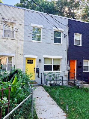 A row of townhouses with a narrow pathway leading to the entrance.