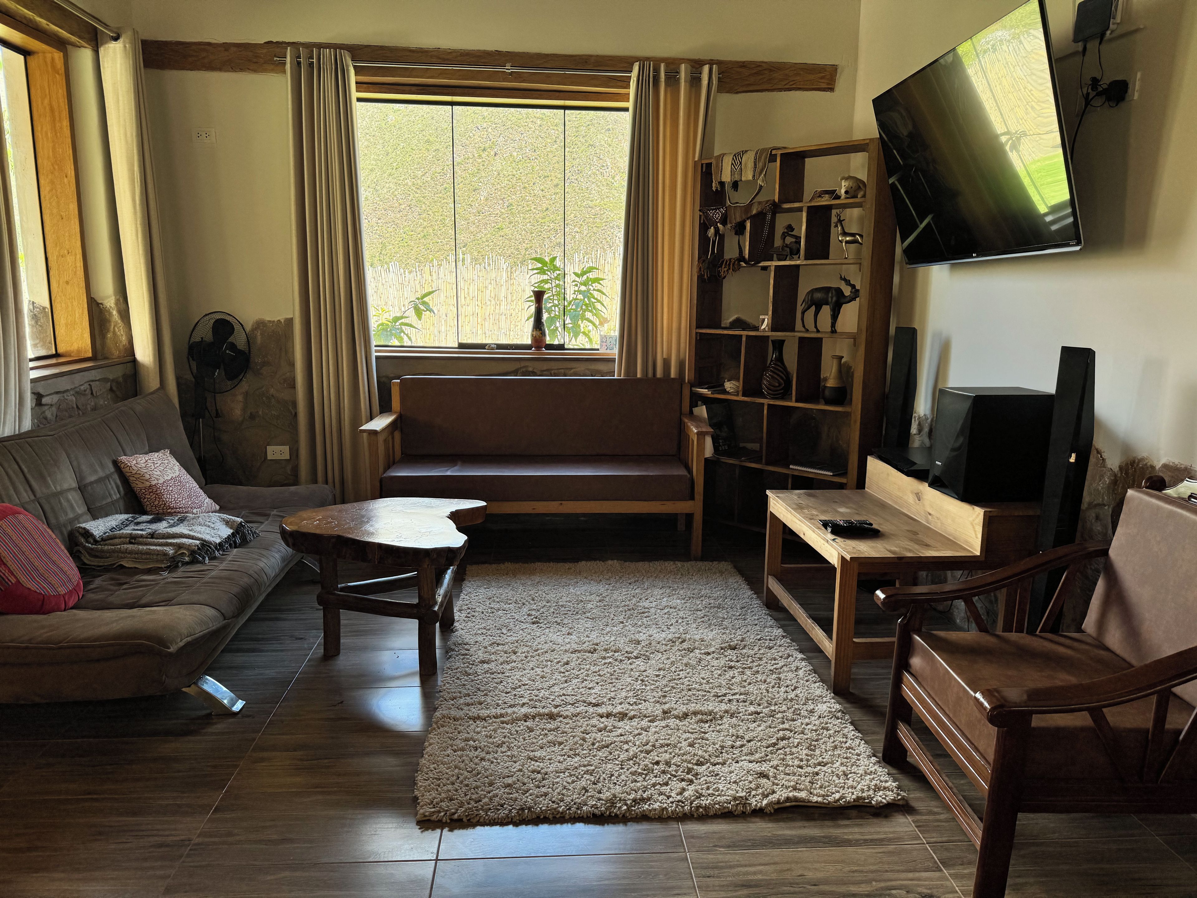 A living room with a sofa, a coffee table, a TV, and a bookshelf.