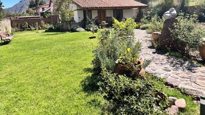 A house with a tiled roof, surrounded by a well-maintained lawn and potted plants.
