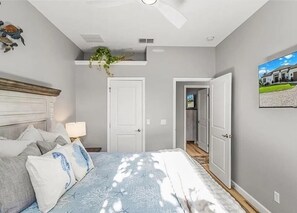 A bedroom with a bed, a ceiling fan, a nightstand, and a door leading to another room. - Crystal River Waterfront w/ Dock, Pool & Manatees! (Crystal River)