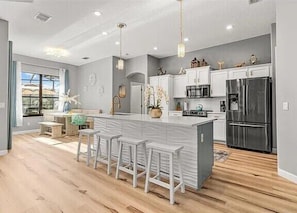A modern kitchen with a central island, bar stools, and stainless steel appliances. - Crystal River Waterfront w/ Dock, Pool & Manatees! (Crystal River)