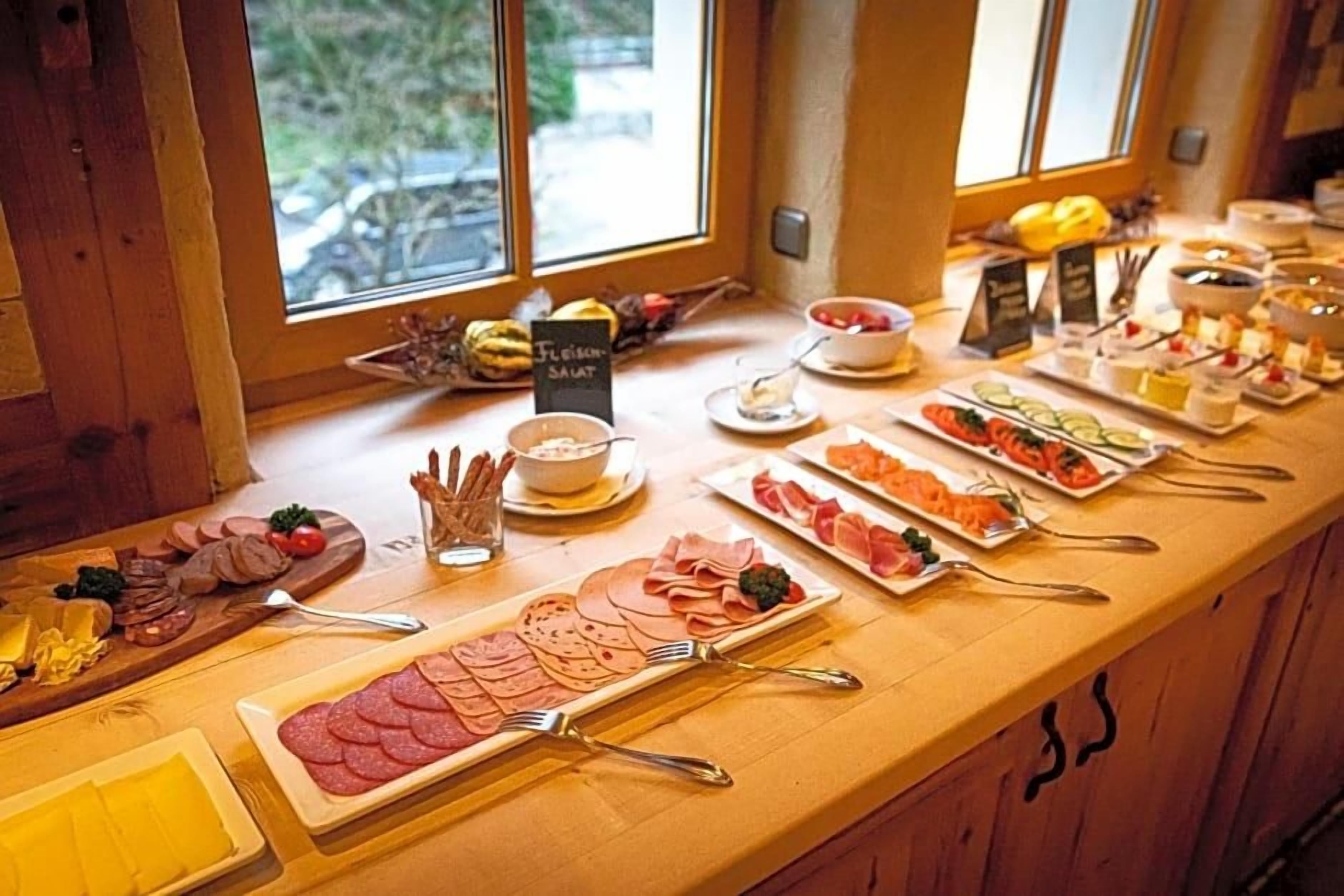 Ein Buffet mit verschiedenen Speisen und einem Schild mit der Aufschrift 'Frischer Salat'.