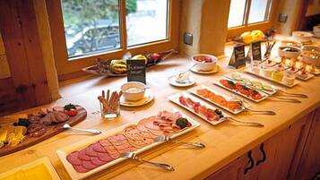 Ein Buffet mit verschiedenen Speisen und einem Schild mit der Aufschrift 'Frischer Salat'.