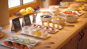 Ein Buffet mit verschiedenen Speisen sowie einem Schild, das 'Quark' und 'Ziegen-Frischkäse' ausweist.
