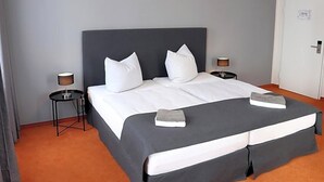 Ein Hotelzimmer mit einem Bett, zwei Nachttischen und einer Tür.