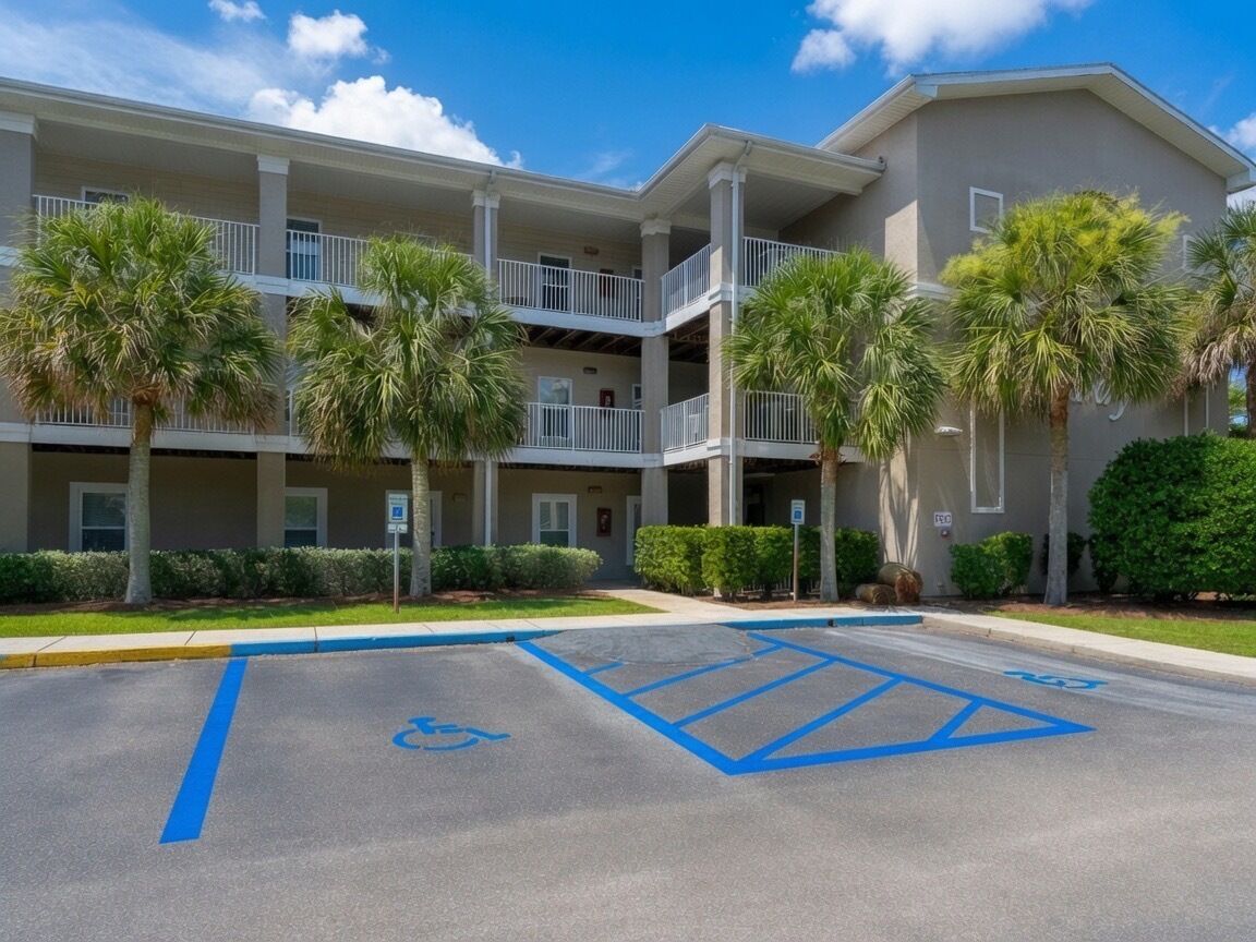 Un hôtel à plusieurs étages doté d’un parking avec des places réservées aux personnes handicapées.