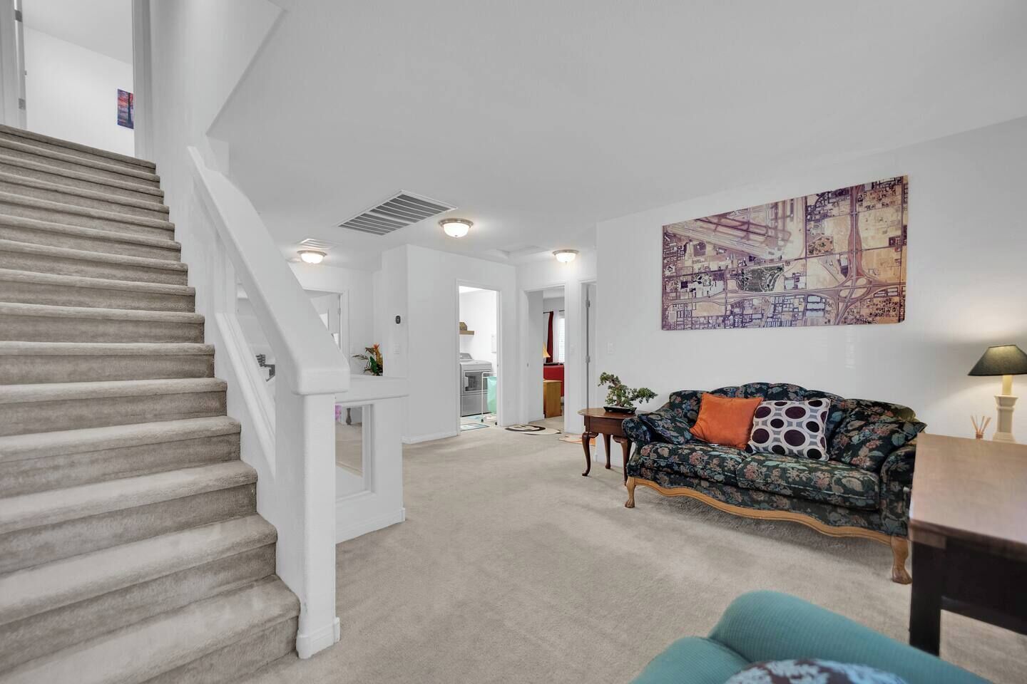 Un vaste espace de vie comprenant un escalier, un canapé et un coin repas.