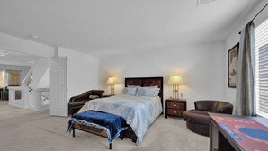 Quarto com cama, duas mesas de cabeceira, uma cadeira, escrivaninha e escada.