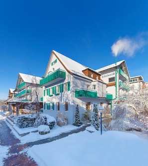 A large, multi-story hotel with a snow-covered exterior and green shutters, featuring a prominent sign. - Edelweiss (Bad Woerishofen)