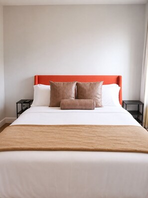 A bed with a white mattress, brown pillows, and a brown throw blanket.