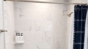 A bathroom with a bathtub, a shower area, and a toilet.