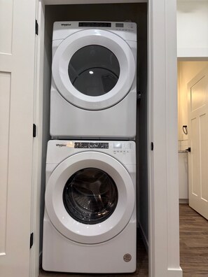 A compact laundry room with two stacked Whirlpool front-loading washing machines.