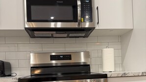 A kitchen with a stainless steel microwave, oven, and stovetop.