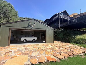 Un garaje con un coche blanco, una decoración de cornamenta de venado y un patio de piedra.
