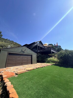 Una casa amb garatge, un camí de pedra i un jardí en verd.