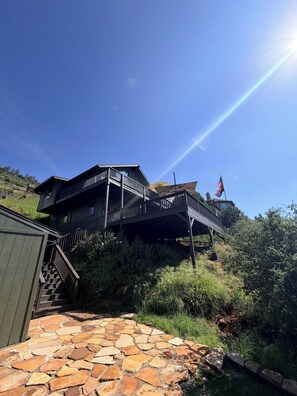 A multi-level wooden house with a stone pathway leading to a staircase. - 3-bedroom cabin in charming Pine with cozy mountain vibes and AMAZING views (Pine)