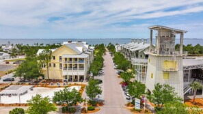 A coastal hotel with a central walkway, beachfront view, and a lifeguard tower. - Brand-New 4-Bedroom Coastal Escape in WindMark Beach (Port St. Joe)