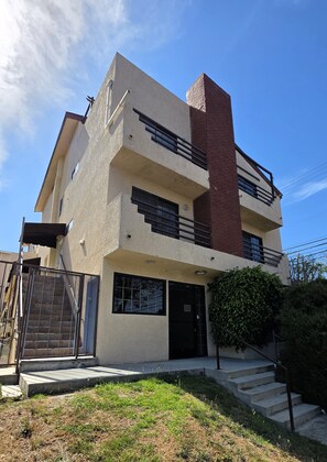 A multi-story building with a brick chimney, a gated entrance, and a small front yard with steps leading to the door. - 2 Bedroom Apt 5 minutes from Rodeo Dr Walk to Restaurants and Markets (Beverly Hills)