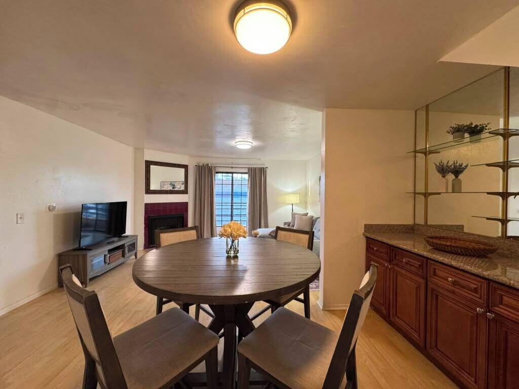 A modern kitchen with a round dining table, wooden chairs, and a built-in stove.