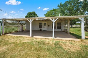 A white, single-story building with a covered porch labeled 'BUNKHOUSE.'
