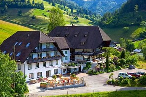 A traditional building with a courtyard, multiple windows, and a staircase leading to an upper level. - Landhaus Langeck (Münstertal)