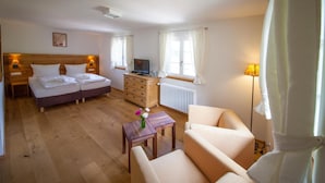 Une chambre d’hôtel équipée d’un lit, d’un bureau, d’une chaise, d’un radiateur et d’une télévision.