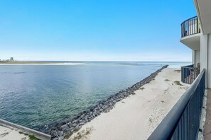 A beachfront property with a clear view of the ocean, a sandy beach, and a rocky shoreline. - Grand Pointe 603 | Beachfront, Pools, Saunas, Hot Tub | My Beach Getaways (Orange Beach)