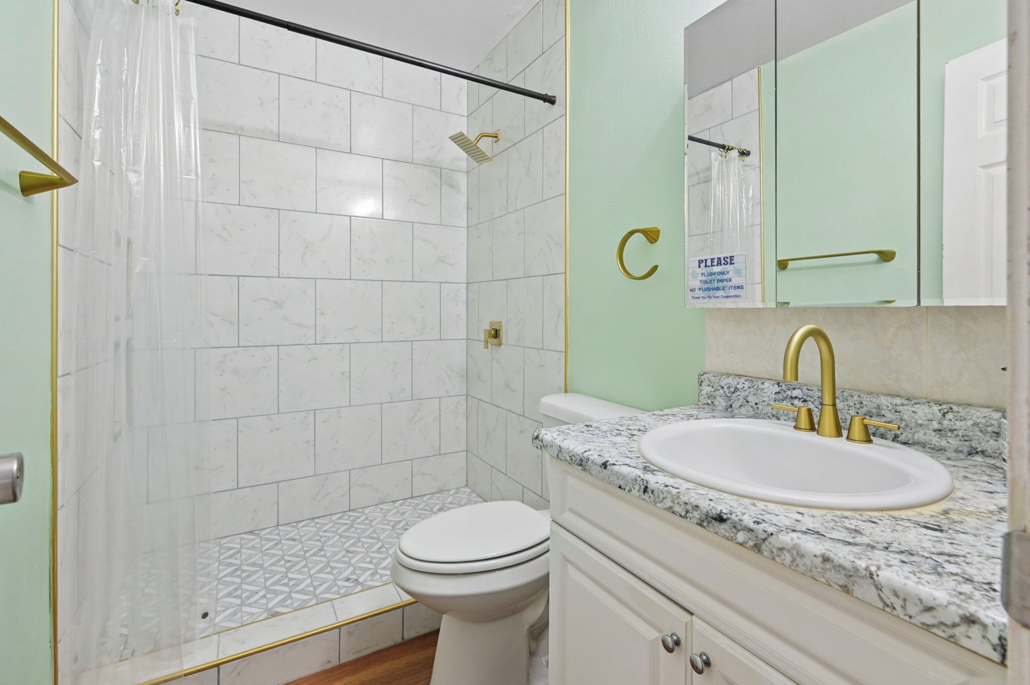 A bathroom with a shower, toilet, and sink.