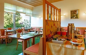 A dining area with tables set for meals, chairs, and a buffet table with food items. - Schleifmühle (Holzminden)
