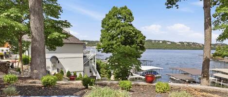 Una propiedad frente al lago con una terraza, mobiliario exterior y vistas al agua.