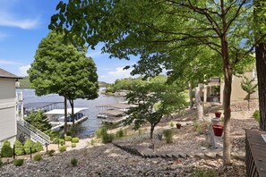 Une propriété au bord du lac, dotée d’un quai, d’un abri pour bateaux et d’un sentier en pierre menant à un bâtiment.