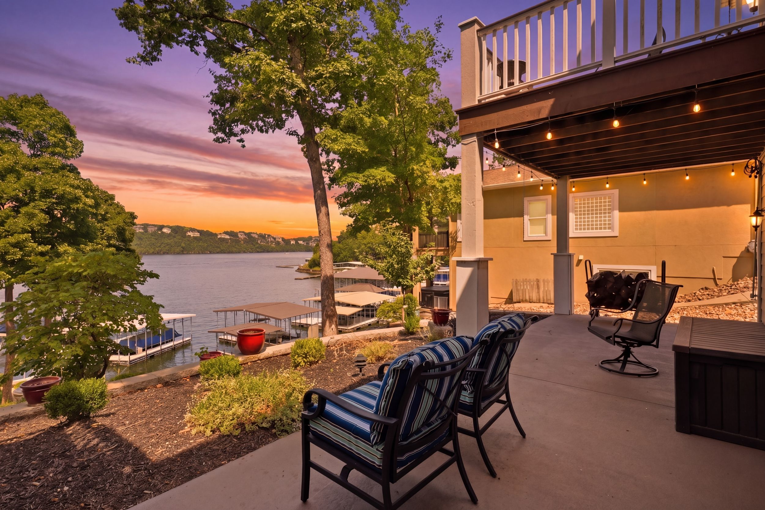 A waterfront patio with outdoor seating, a grill, and a view of the lake.