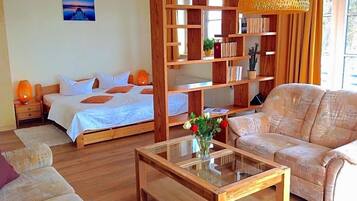 Ein Zimmer mit einem Bett, einem Sofa, einem Couchtisch und einem Bücherregal.