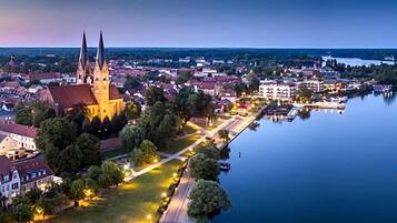 Eine Stadt mit einem markanten Kirchengebäude, einem ruhigen Fluss und einem Anleger.
