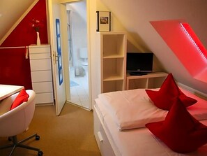 A bedroom with a bed, a desk, a chair, a television, and a wardrobe. - Altes Kasino (Neuruppin)