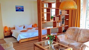Una habitación con una cama, un sofá, una mesita de café y una estantería.