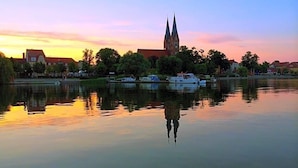 Un río tranquilo con barcos, una iglesia y edificios reflejados en el agua.