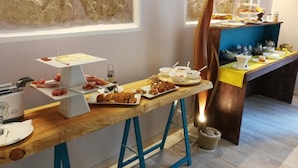 A buffet setup with various food items and a toaster. - Emporium Case Vacanze (Castellammare del Golfo)