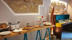 A breakfast buffet with various food items and a decorative wall. - Emporium Case Vacanze (Castellammare del Golfo)