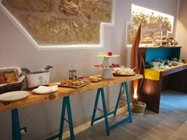 A breakfast buffet with various food items and a decorative wall.